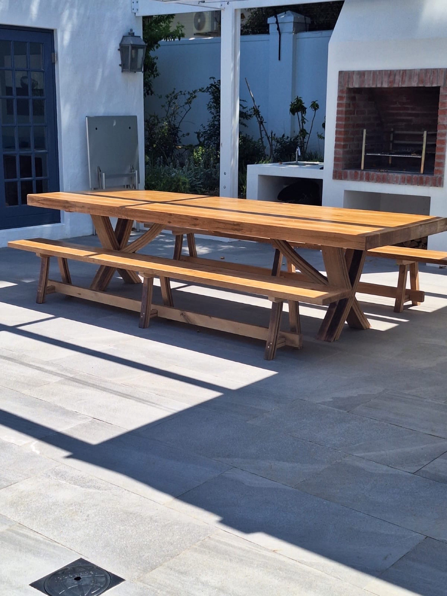 Solid French-oak refectory table with matching benches on a sunlit patio
