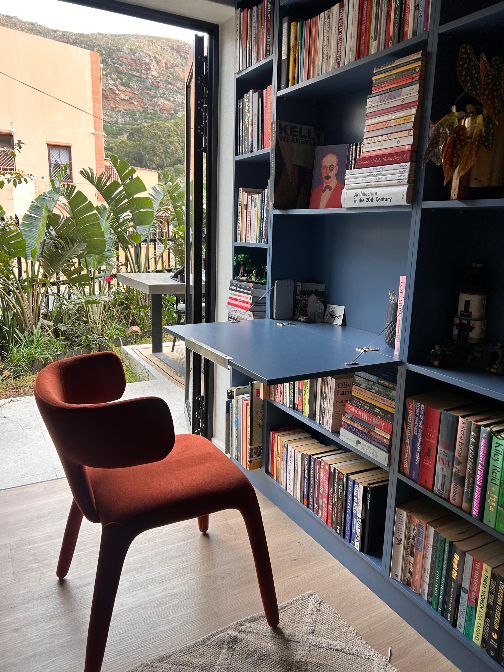 Built-in navy library with a fold-out oak desk and mountain view